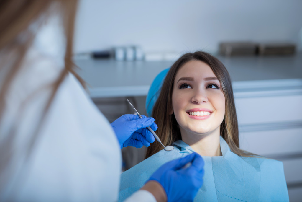 a woman is smiling at her female dentist