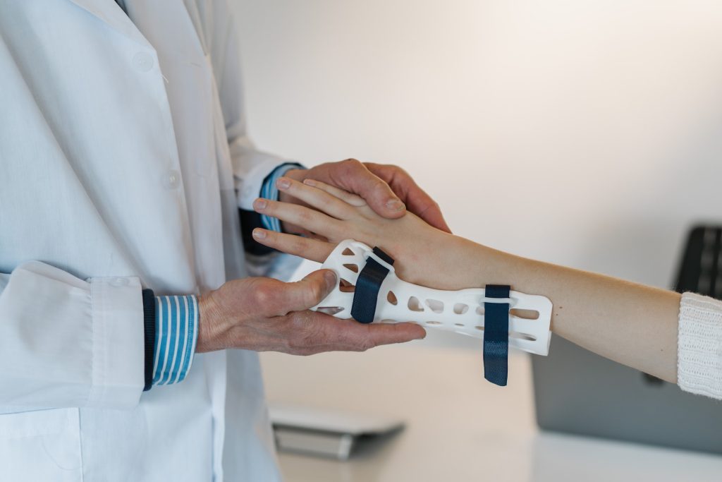 doctor fitting 3D printed hand brace on patient