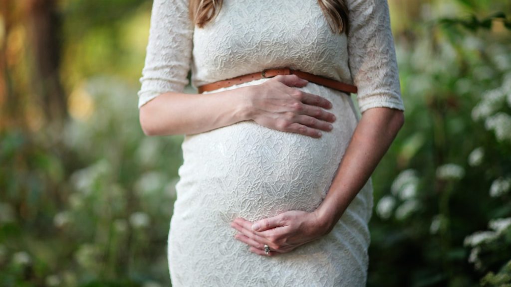 pregnant woman holding her tummy