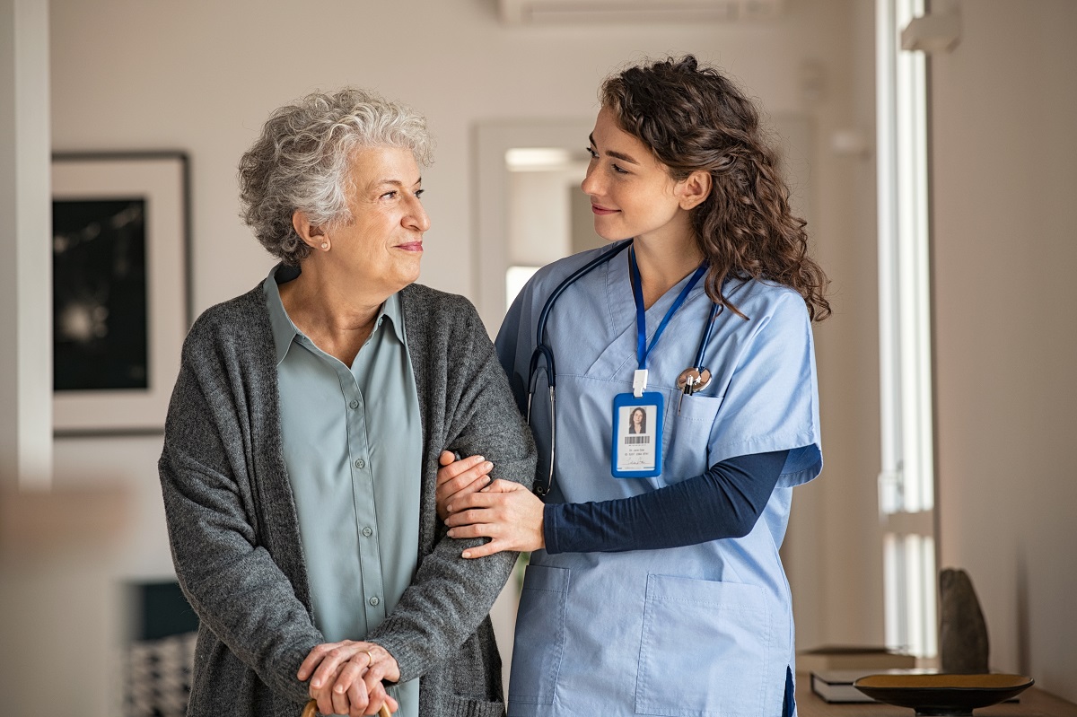 a nurse supporting an elderly patient